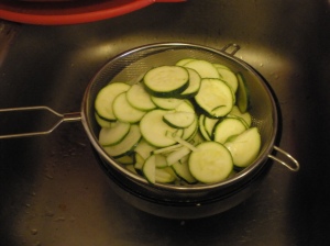 zucchini in a strainer over a bowl